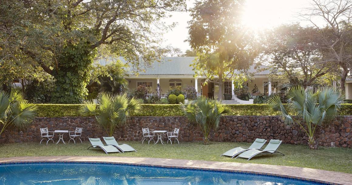 Batonka Guest Lodge pool and gardens at sunset in Victoria Falls
