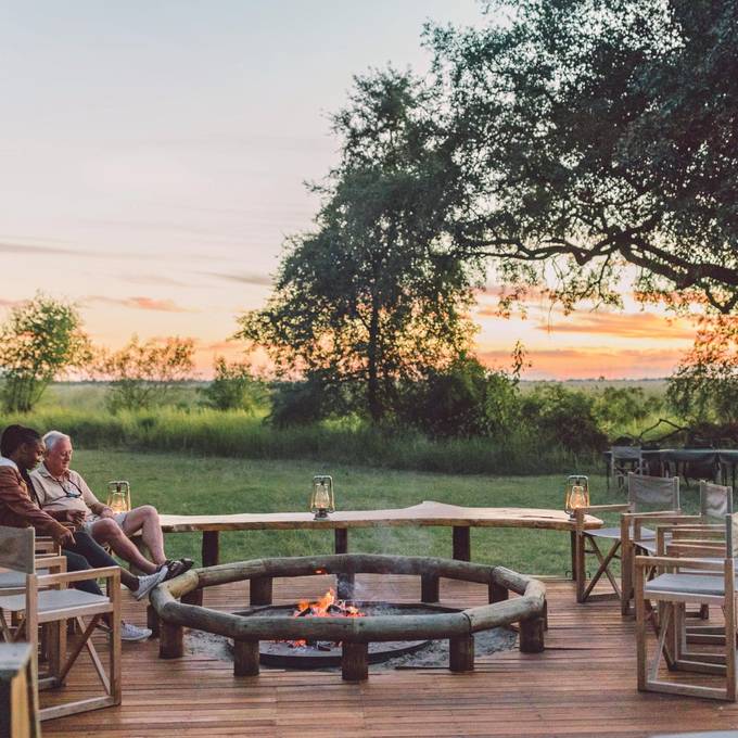 Camp Moremi campfire and lanterns at sunset in Moremi Game Reserve