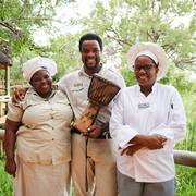 Camp Moremi guide and chefs smiling on the walkway