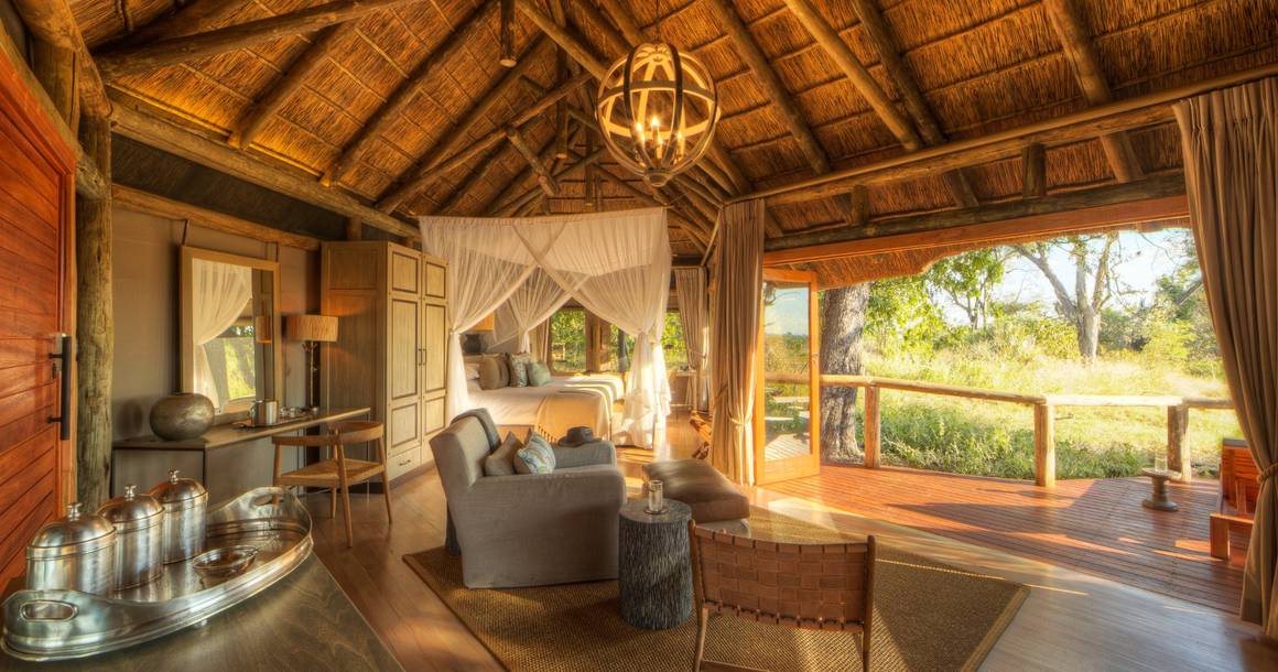 Camp Moremi thatched suite with canopy bed and bush view