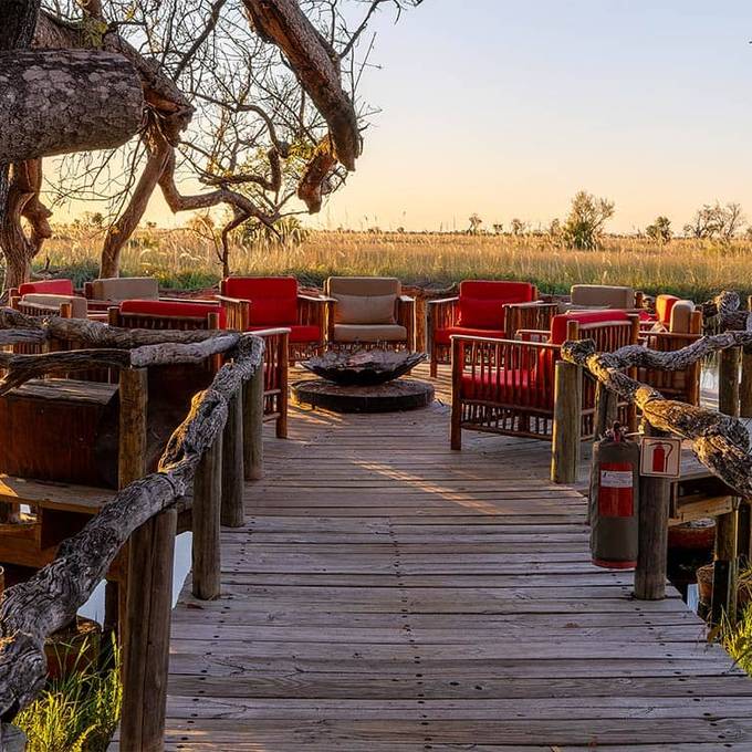 Camp Xakanaxa boma and fire deck overlooking the lagoon at sunset