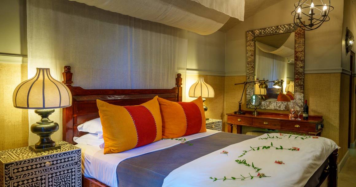 Chobe Game Lodge bedroom with canopy bed and inlaid decor