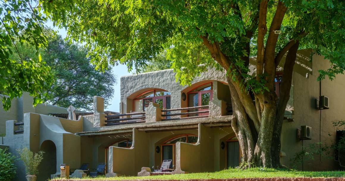 Chobe Game Lodge exterior with garden and riverine trees