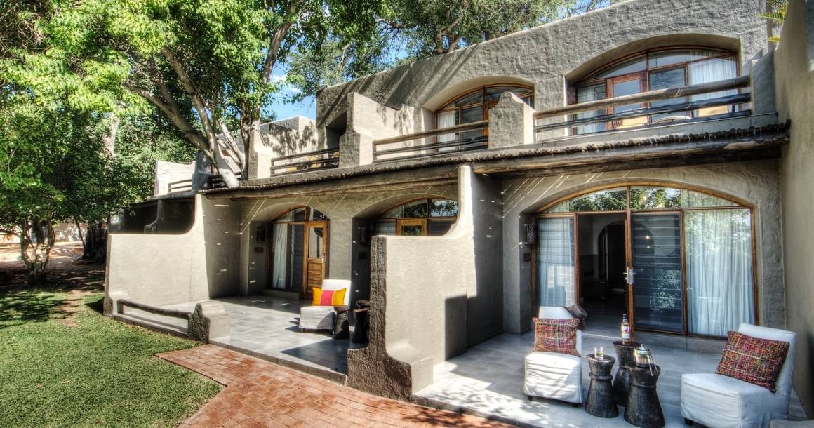 Chobe Game Lodge room exterior with private terrace and garden