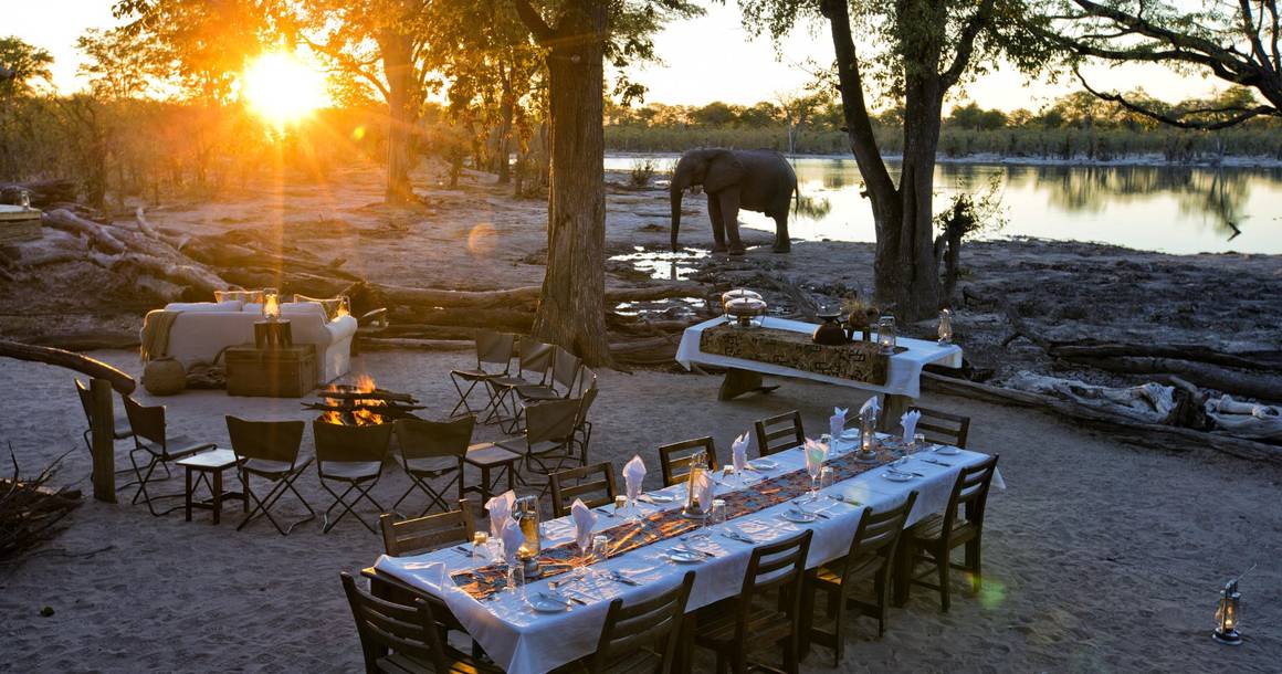 Elephant Pan outdoor dining at sunset with elephants at the waterhole