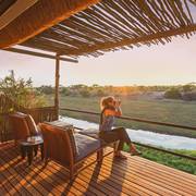 Guest with binoculars on Leroo La Tau deck overlooking the Boteti