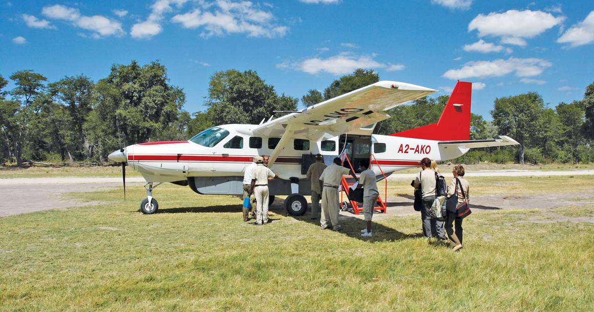 Guests boarding a Safari Air Cessna on a Botswana bush airstrip