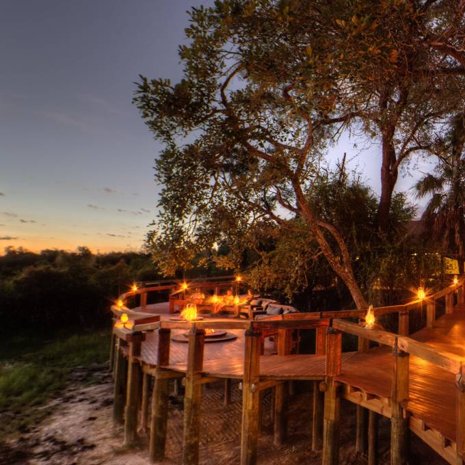 Lantern-lit dining deck at Camp Okavango in the Okavango Delta
