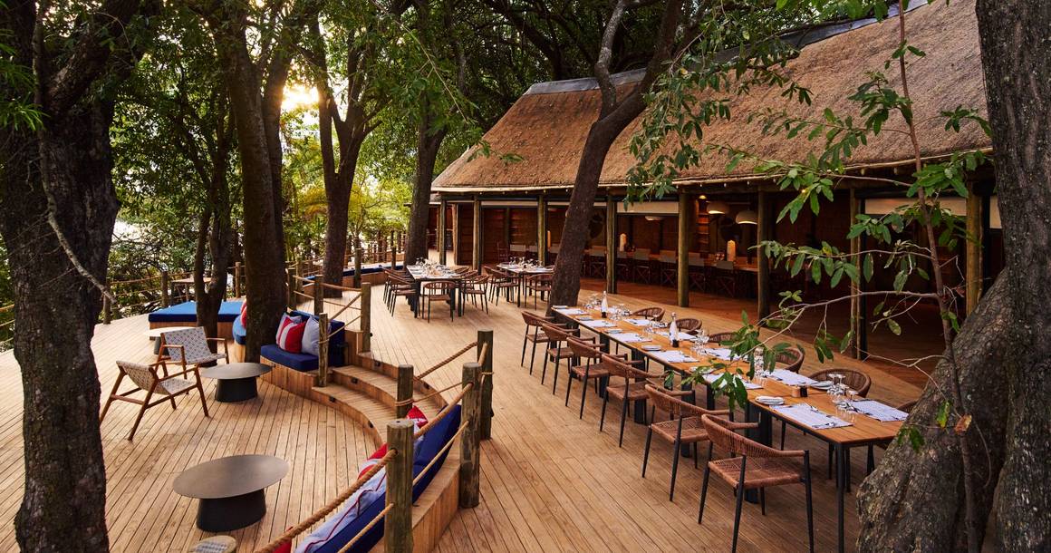 Xugana Island Lodge dining deck beneath ancient trees